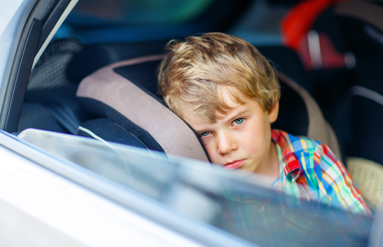 Child in carseat looking sad