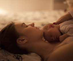 Tired mother sleeping with newborn baby on chest - feature