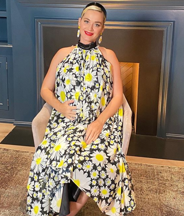 Pregnant Katy Perry wearing a flowing dress covered with daisies