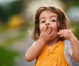 Little girl covering her mouth in surprise