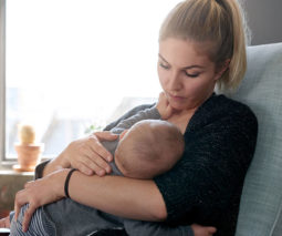 Mum breastfeeding baby with a serious face