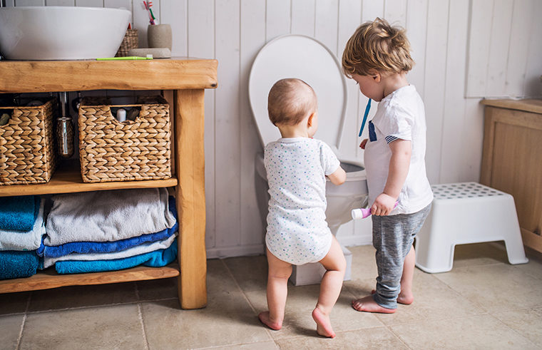 Two boys toddler and baby playing with toilet - feature