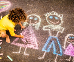 Child drawing with chalk on footpath