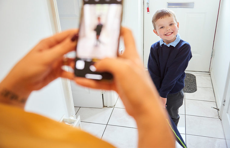 Parent taking a photo of little boy before school