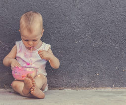 Messy baby sitting eating ice cream - feature