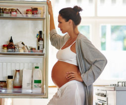 Pregnant woman looking for food in the fridge