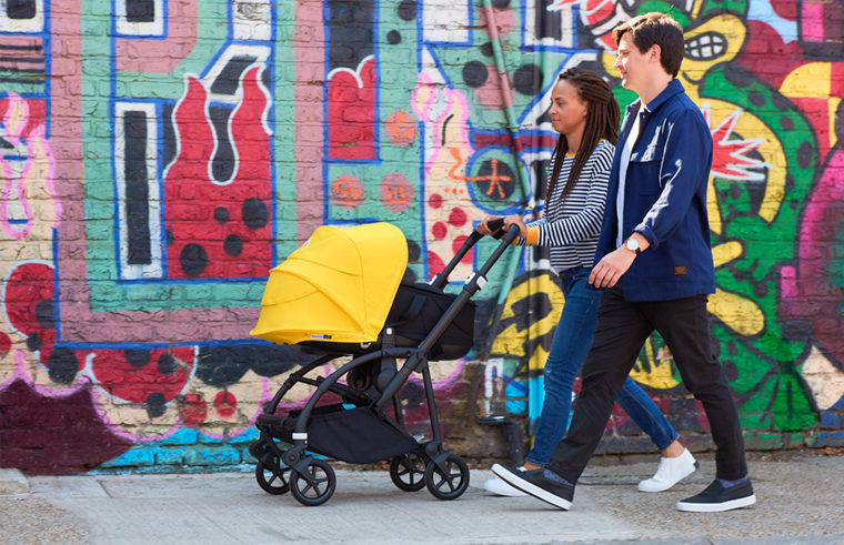 Couple walking with child in Bugaboo Bee 6 pram