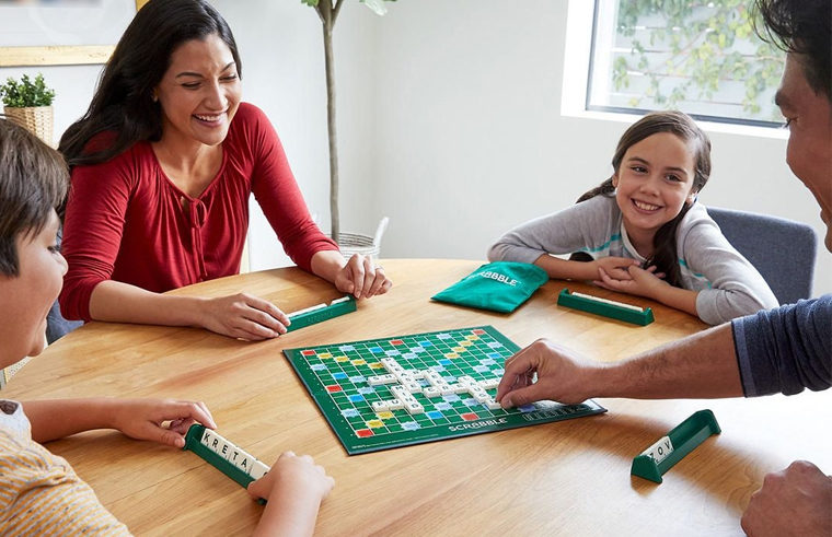 Family playing the boaord game Scrabble at dining table