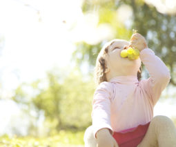 Toddler girl eating grapes outside
