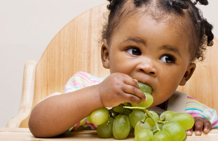Toddler eating grapes