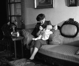 Vintage woman feeding baby - feature