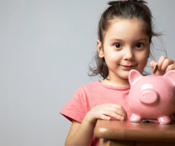 Girl putting money into a piggy bank