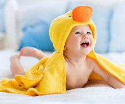 Happy baby in yellow towel