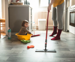 Mum mopping floor with little girl on the floor