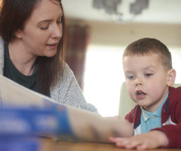 Mother and son reading school book together - feature