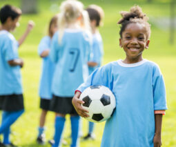 Girl playing soccer in blue shirt