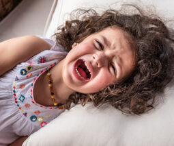 Little girl crying on pillow