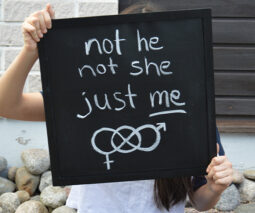 A child holding up a sign about being non binary