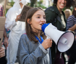 Young girl on a speaker phone at climate rally