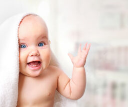 Baby with towel on head looking surprised - feature